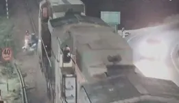 Flagrante de imprudência - motociclistas empurram moto sobre trilhos, ignorando aproximação do trem