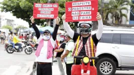 Arte-educadores da Rádio Margarida usam cartazes e mímica na performance lúdica para garantir segurança a condutores e pedestres.