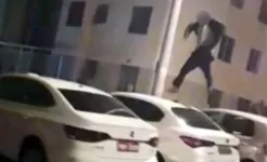 Imagem ilustrativa da notícia Imagens fortes! Jovem pula em cima de automóveis, cai e 'se quebra'