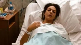 Nicole aparecia deitada em uma cama de hospital, com expressão de dor