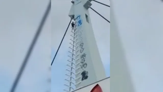 Imagem ilustrativa da notícia Risco de morte: homem é flagrado escalando Pórtico Metrópole para pichar. Assista!