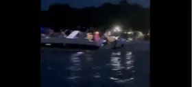 Pessoas aglomeradas em barcos e iates na ilha.