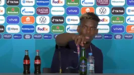 Pogba faz igual Cristiano Ronaldo e tira uma garrafa de cerveja de cima da mesa, em entrevista coletiva.