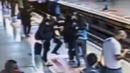 Câmeras de segurança flagraram o momento em que um homem tenta empurrar uma passageira em direção aos trilhos de um metrô.