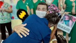 Paciente Bienor Cunha emocionado reencontrando a mãe na saída do hospital. 