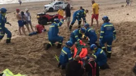 Equipes de salvamento resgatando o jovem das areias