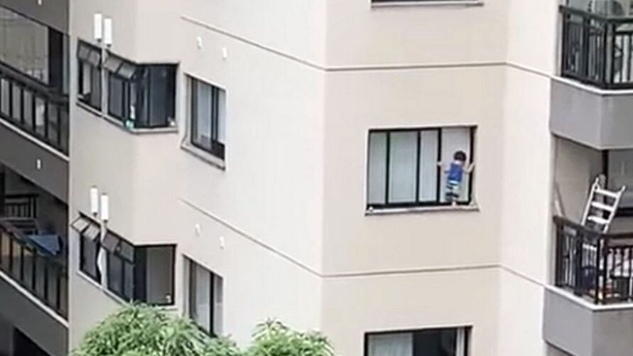 Criança se equilibra na janela de apartamento e moradores ficam em pânico.