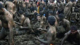 Vários homens participam de guerra de estrume durante o festival "Gorehabba" em Gumatapura, Índia
