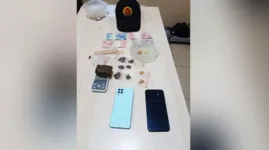Durante a busca pessoal foi encontrado um pequena quantia em dinheiro, dois aparelhos celulares e o produto que fora descartado na hora da fuga