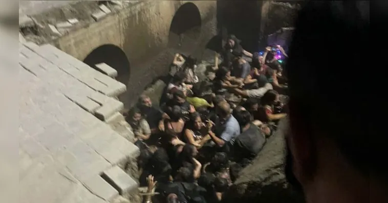 Imagem ilustrativa da notícia Vídeo: calçada cede e pessoas caem durante festa de Natal