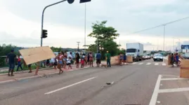 Homens, mulheres e crianças fecharam as duas faixas da rodovia com pedaços de compensados usados para construção dos abrigos