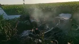 O avião é encontrado em chamas em meio ao milharal