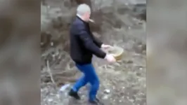 Homem caminha com a bomba nas mãos