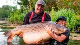 Callum Pettit, 11, com o pai, Stuart, 40, no momento em que conseguem tirar o enorme peixe da rede