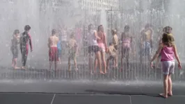 Para aliviar o calor, crianças se refrescam nas praças públicas de Londres.