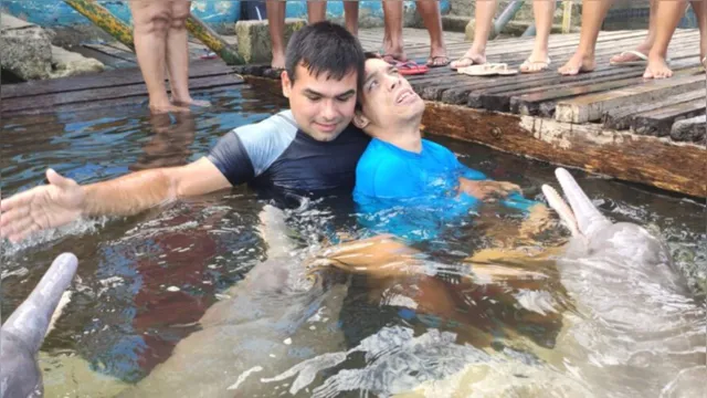 Imagem ilustrativa da notícia Rapaz com paralisia cerebral nada com os botos no Pará