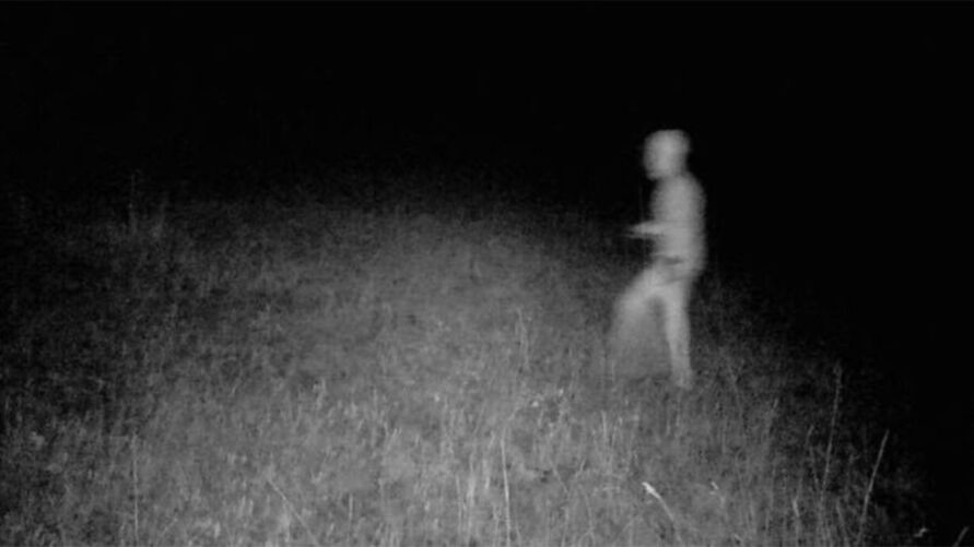 Imagem mostra um ser estranho caminhando na frente de uma câmera de caça noturna