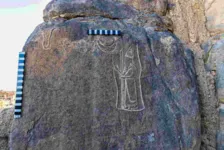 A gravura mostra o rei babilônico de pé com um cetro na mão, além de quatro símbolos, uma lua crescente.