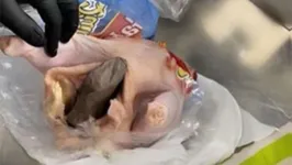 Os agentes descobriram a arma de fogo embrulhada em plástico e colocada dentro do frango.