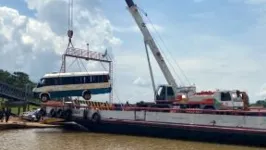 Micro-ônibus foi retirada da água com ajuda de guindaste.