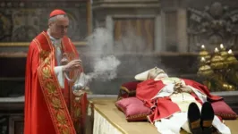 Cardial Mauro Gambetti passa com incenso por corpo do papa emérito Bento 16, velado na Basílica de São Pedro.