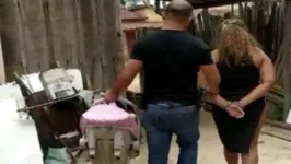 Investigador da Polícia Civil conduz a mulher acusada pelo sequestro do bebê.