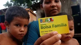 Família de beneficiários do Bolsa Família exibe cartão