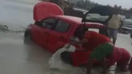 Pessoas tentaram tirar carro preso na praia do Farol Velho, em Salinas