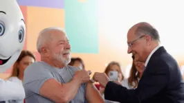 O presidente Luiz Inácio Lula da Silva sendo vacinado pelo vice-presidente Geraldo Alckmin.