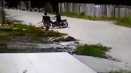 Depois de ferir a vítima, um dos criminosos consegue tomar a bolsa, sobe na moto e foge do local.
