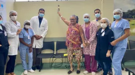 Equipe hospitalar e paciente Jueliza Monteiro Borges comemoram a alta hospitalar tocando o 'Sino Dourado'