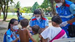 Grupo de indígenas sendo atendido por médicos