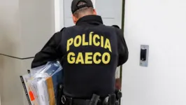 Policial de Goiás recolhe documentos apreendidos pela operação Penalidade Máxima.