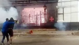 Torcedores vascaínos disparando fogos de artifício contra o portão do estádio São Januário.