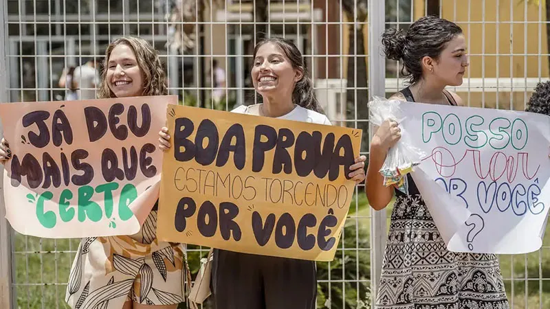 Em frente ao local de prova, cartazes desejando boa sorte aos candidatos