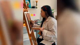 Renata Sousa,  a artista expositora, no processo de pintura