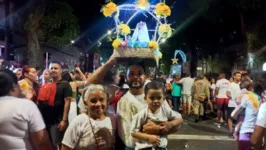 Ao lado da mãe e do filho, o fiel Maurício de Oliveira paga mais uma promessa para Nossa Senhora de Nazaré.