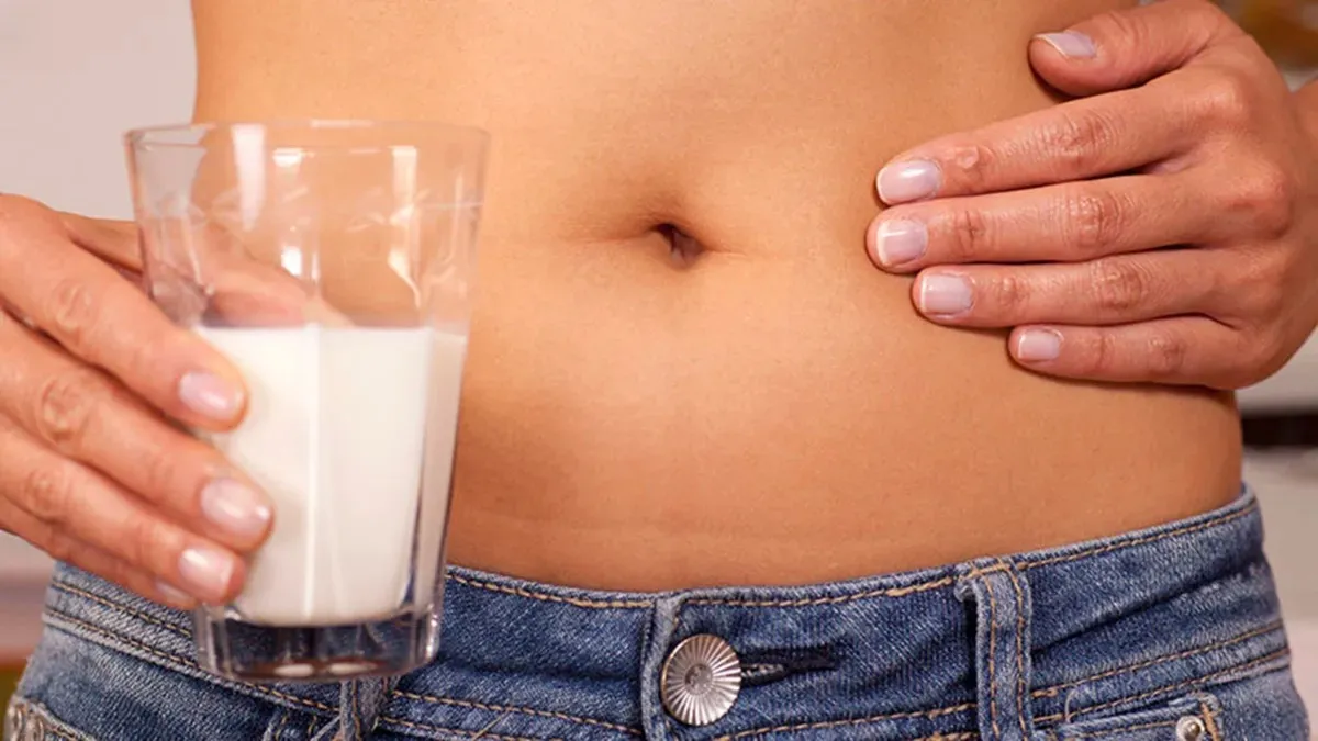 A intolerância ocorre devido à falta da enzima lactase, responsável por quebrar a lactose em partes menores para digestão.
