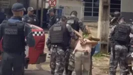 Momento em que acusados são levados para serem apresentados na Delegacia de Polícia Civil