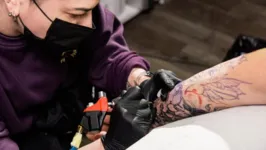 Mulher fazendo tatuagem