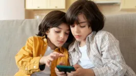 Crianças utilizando celular