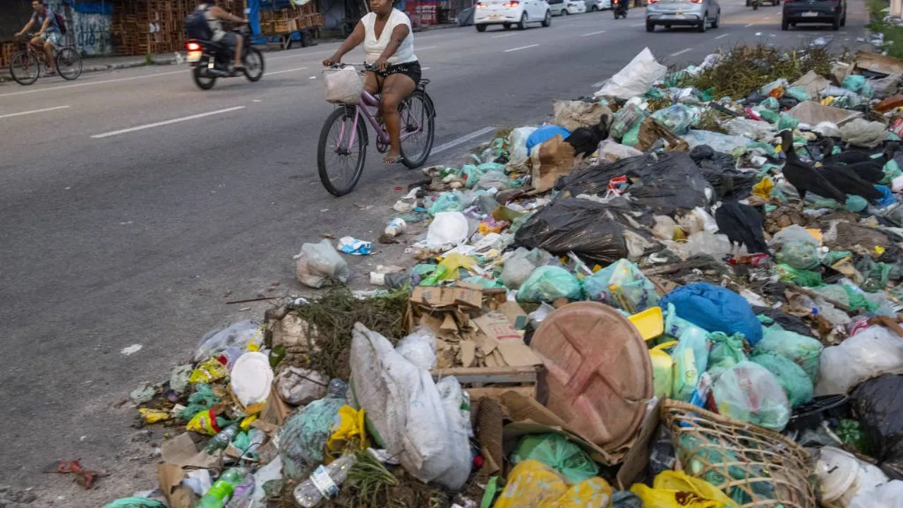 Ciclistas desviam de lixo acumulado na avenida Pedro Álvares Cabral, em Belem.