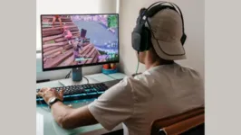 Jovem jogando videogame e usando fone de ouvido