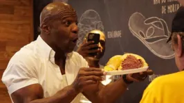 Terry Crews não perdeu a oportunidade de provar o sanduíche de mortadela do Mercadão de SP.