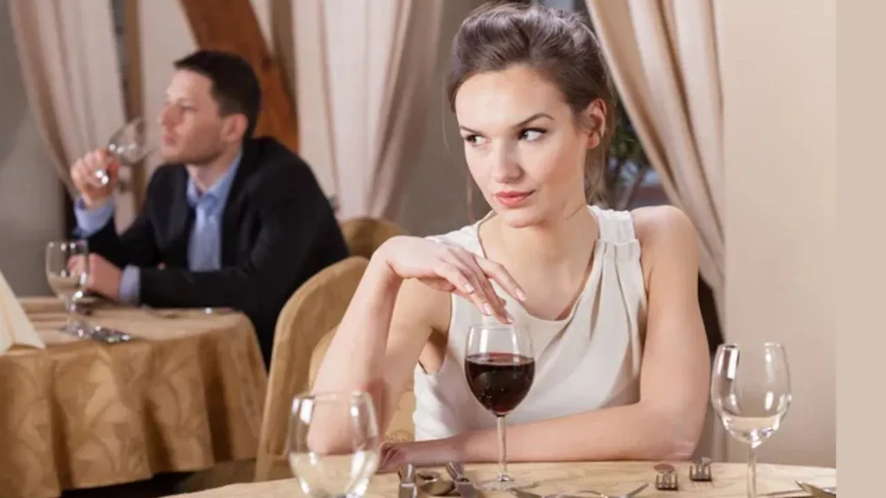 Mulher solteira bebendo vinho em um restaurante