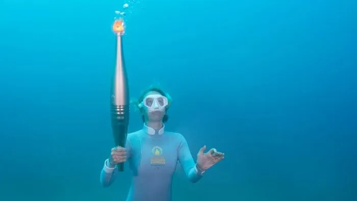 Mergulhadora conduz tocha olímpica durante trecho do revezamento pelo Mar Mediterrâneo.