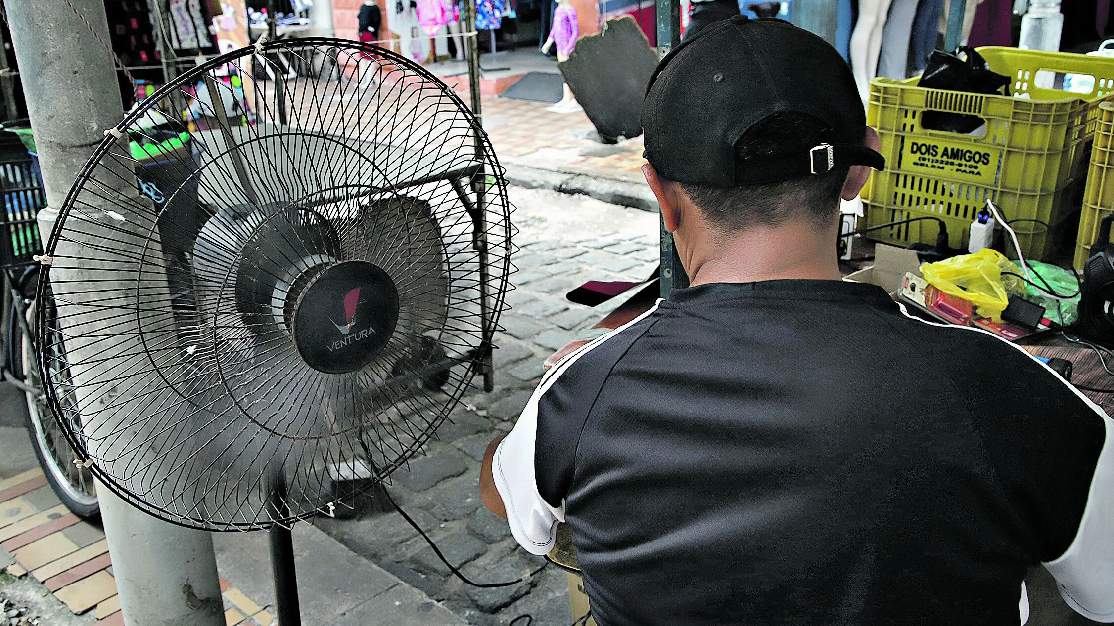 Pessoas usam de várias estratégias para reduzir o calor como o uso de ventiladores e bonés. Maria Almeida investe no protetor solar