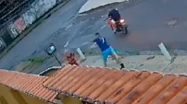 Nas imagens, é possível ver a vítima caminhando pela calçada quando dois criminosos em uma moto se aproximam