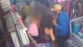 A proprietária (blusa rosa) atacada pelo bando durante o assalto