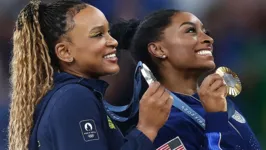 Rebeca e Simone Biles posam para foto no pódio